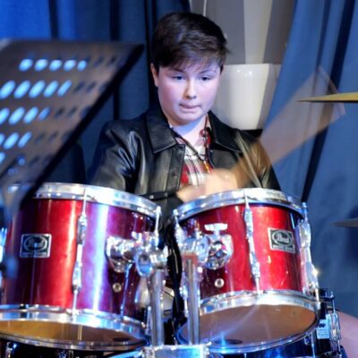 A teenage girl playing the drums at Junior Academy of Modern Music