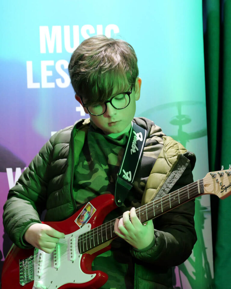 Young boy playing electric guitar at a JAMM workshop in Woking, Surrey
